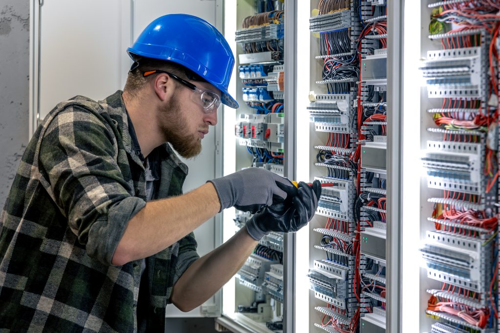 electrician inspects switchboard wiring check screwdriver hand